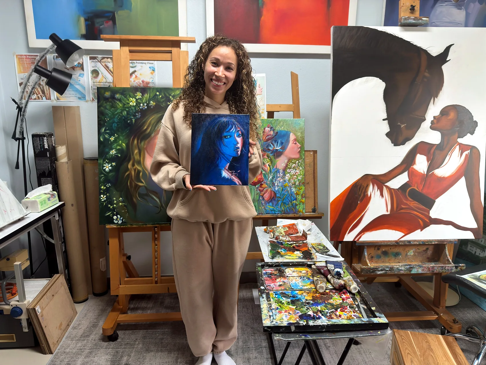 Adult learner presenting a blue portrait painting