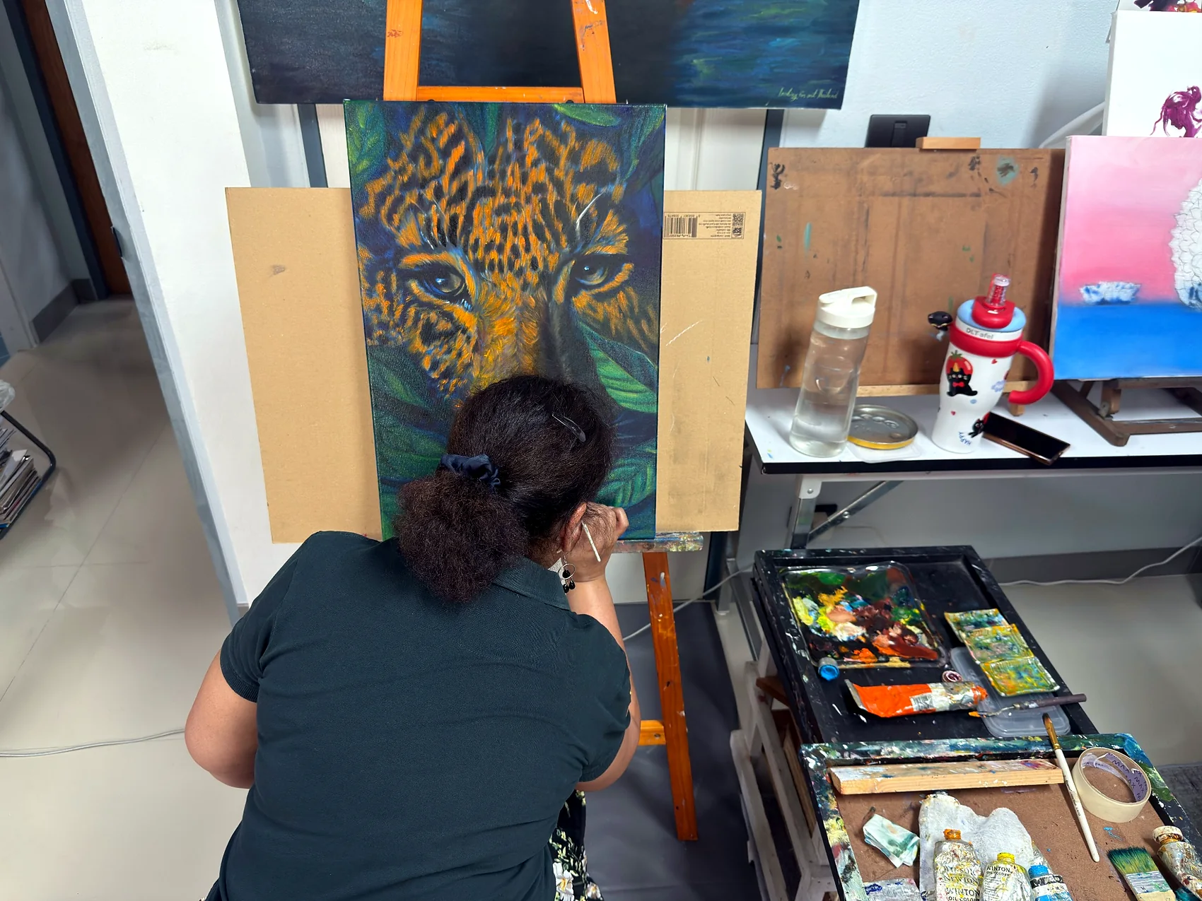 Adult learner painting a leopard at an easel