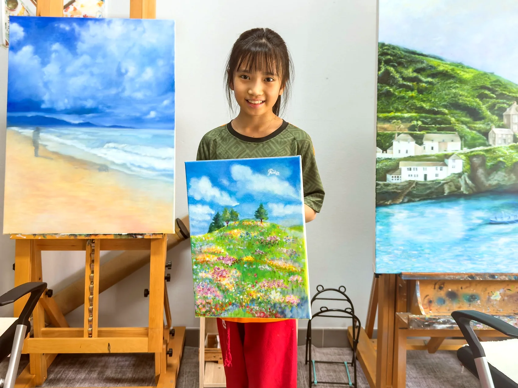 Young artist presenting a colourful landscape painting